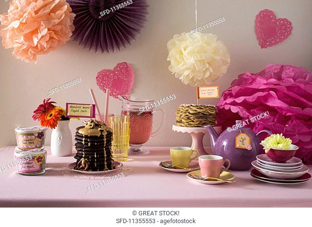 A jolly buffet decorated with paper flowers and various sweet dishes