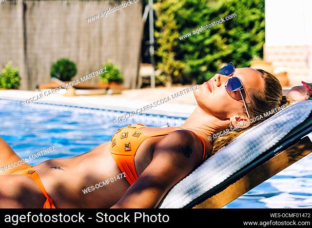 Woman sunbathing at swimming pool