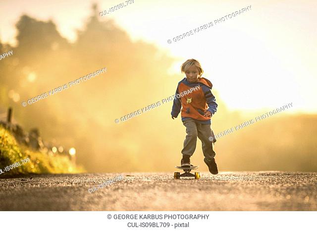 Young boy skateboarding at sunrise, Lahinch, Clare, Ireland