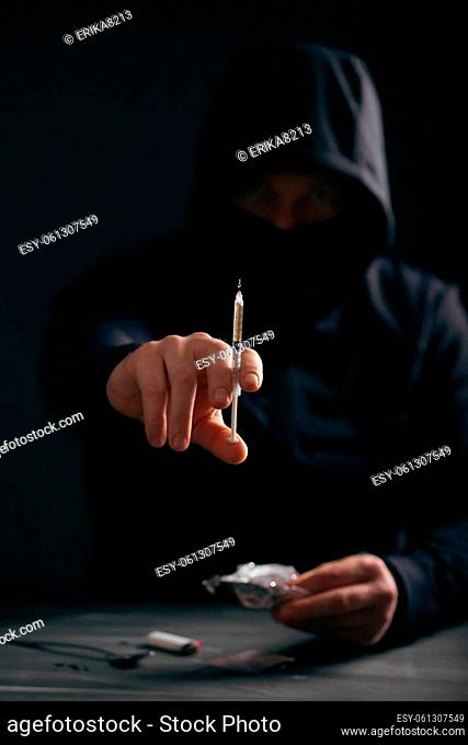 Addict/junkie man preparing drugs. The concept of crime and drug addiction