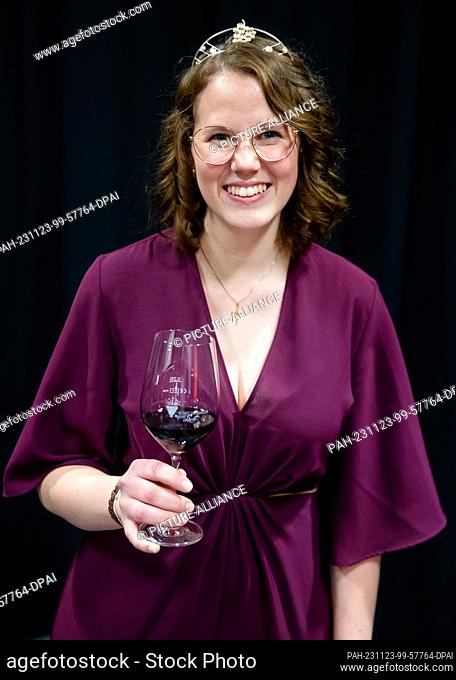23 November 2023, Baden-Württemberg, Massenbachhausen: Larissa Salcher raises a glass of red wine as the 58th Württemberg Wine Queen