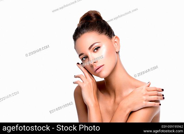 Beautiful young woman with natural makeup touching shoulder. Beauty shot. Isolated over white background. Copy space