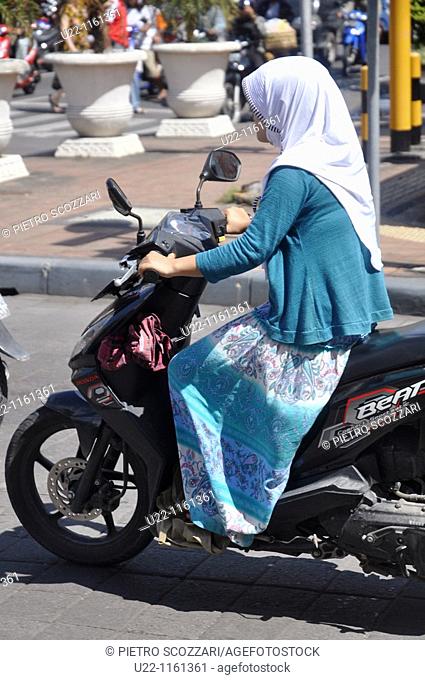 Denpasar (Bali, Indonesia): a Muslim woman driving a motor-bike