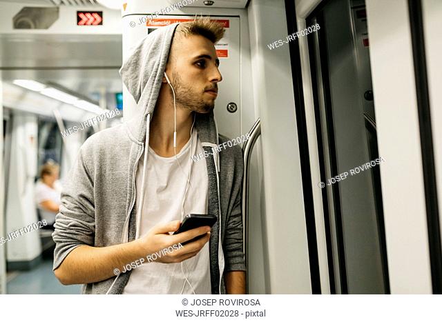 Young man using smartphone in metro