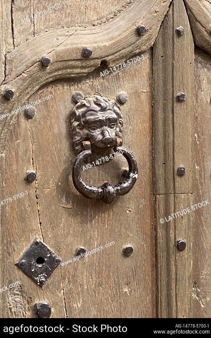 Old fashioned studded wooden door with a lion door knocker