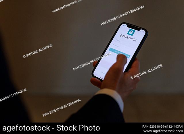08 June 2022, Baden-Wuerttemberg, Donaueschingen: Hotel manager Michael Artner holds a smartphone in his hand, on which an app for recording working hours is...