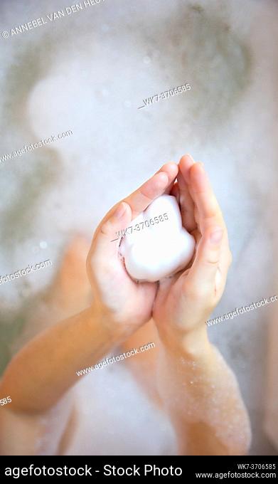 Close up of Woman hands with shampoo or shaving soapy foam in a bath with foam. beauty health care concept top view background