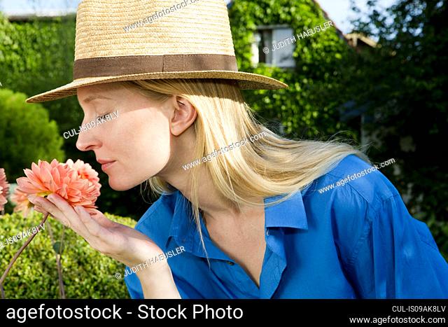 Close up of mid adult woman smelling garden bloom