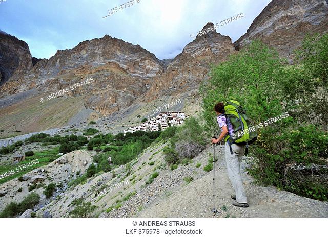 Female hiker looking to Lingshed monastery, Lingshed, Zanskar Range Traverse, Zanskar Range, Zanskar, Ladakh, Jammu and Kashmir, India
