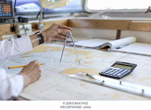 Deck officer working on a nautical map
