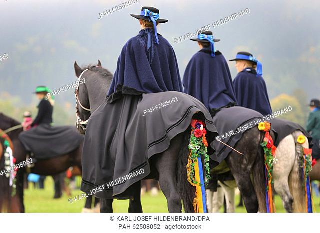 Women in traditional costume sit on festively decorated horses near Schwangau, Germany, 11 October 2015. They are taking part in the feast of St