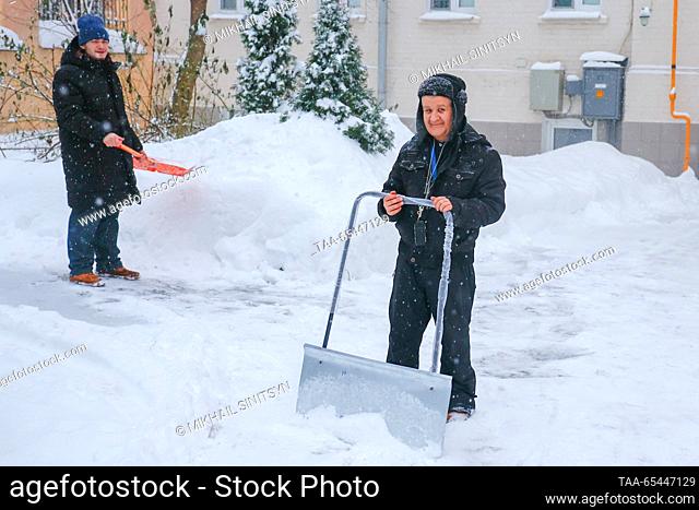 RUSSIA, MOSCOW - DECEMBER 3, 2023: Men shovel snow after a snowfall. Mikhail Sinitsyn/TASS