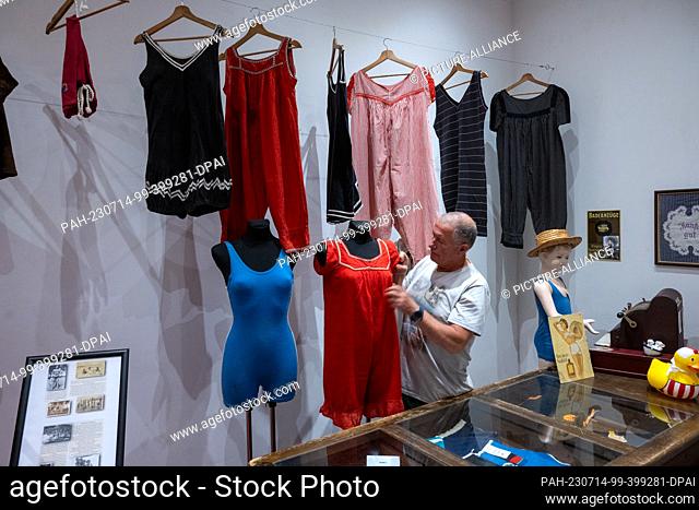 29 June 2023, Mecklenburg-Western Pomerania, Heringsdorf: Jürgen Kraft, swimwear collector, shows a swimsuit from the 1910s in the experience exhibition in the...