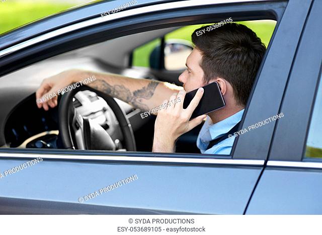 man driving car and calling on smartphone