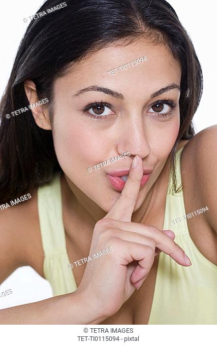 Portrait of woman with finger to lips