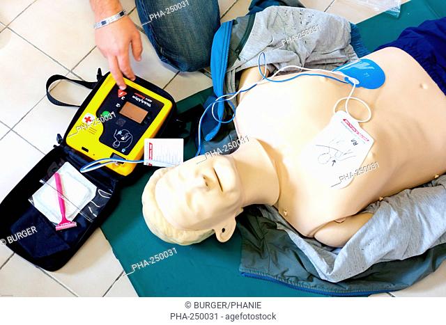 First aid training courses. Portable semi-automatic heart defibrillator used on a mannequin