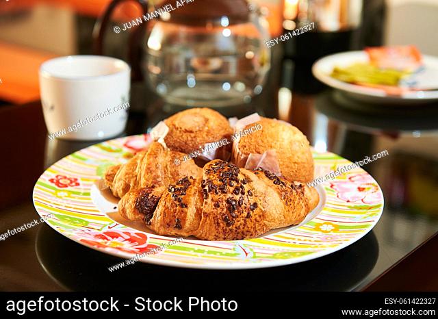 Plate with chocolate croissants and muffins for breakfast