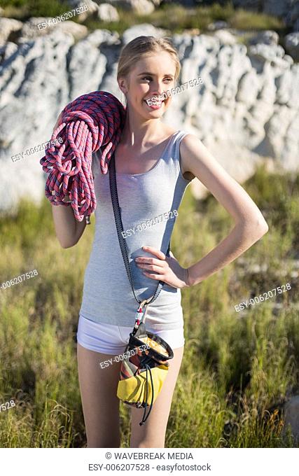 Smiling woman holding climbing equipment