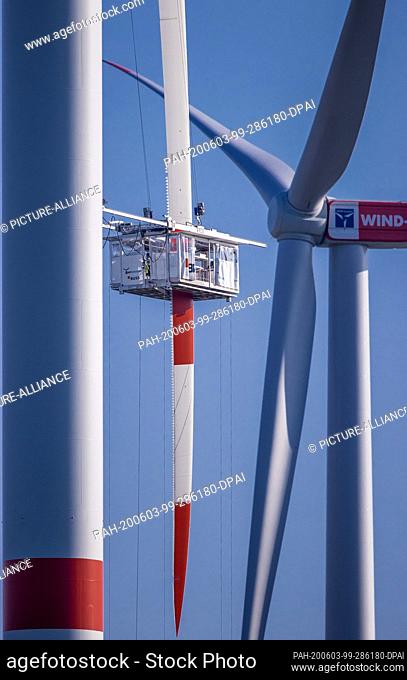 27 May 2020, Mecklenburg-Western Pomerania, Dummerstorf: Specialists maintain a rotor blade from a nacelle at a wind turbine of the operator Wind-Projekt