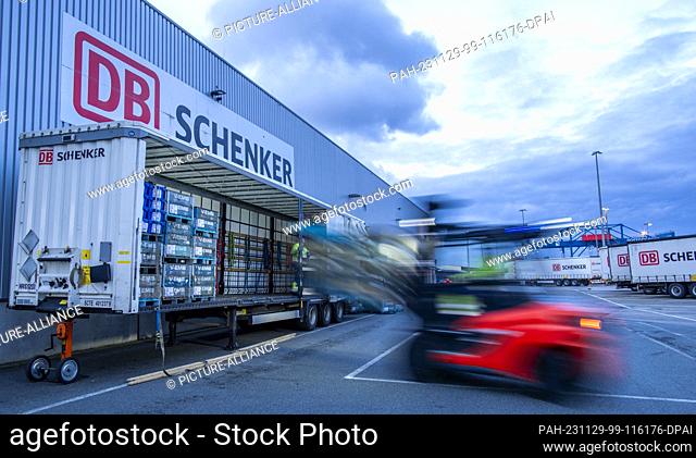 PRODUCTION - 21 November 2023, Mecklenburg-Western Pomerania, Rostock: Pallets and transported goods are unloaded from trailers of the logistics company DB...