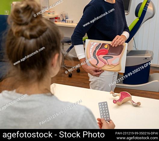 PRODUCTION - 12 December 2023, Bavaria, Planegg: Gynecologist Stephanie Eder gives a young patient the contraceptive pill in her gynecologist's office