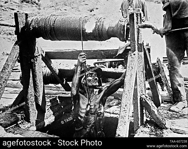 1900s. Baku Gubernia, Russian Empire. Workers extract oil by well method. The exact date of the photograph is unknown. Reproduction by TASS