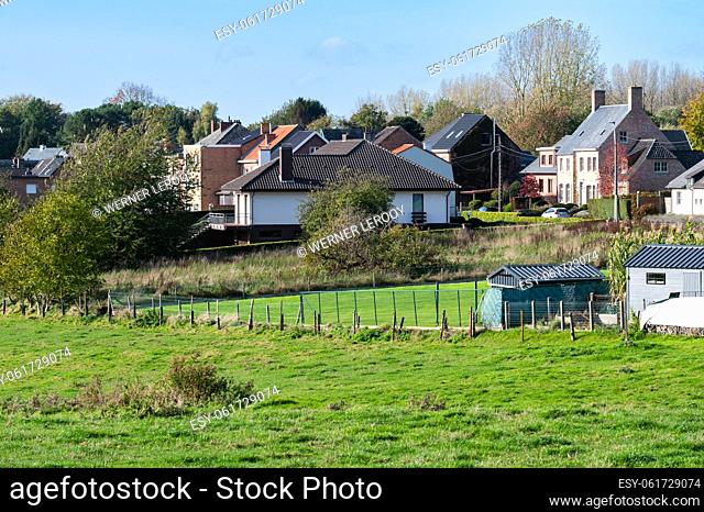 Asse, Flemish Brabant Region, Belgium - Scenic view over green hills and meadows ith residential houses in the background