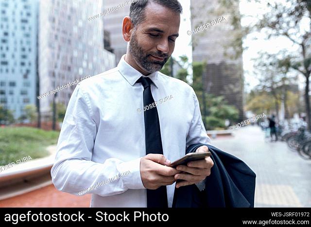 Businessman using smart phone outdoors