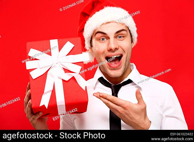 Christmas Concept - portrait close-up Santa christmas businessman over red background holding red gift