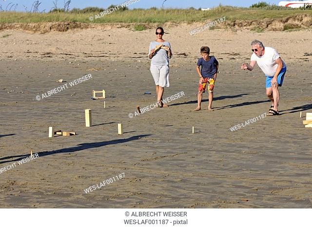 Parents and son playing Kubb on the beach