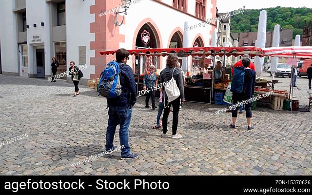 Abstand halten ist weiterhin das oberste Gebot, wie hier an einem Marktstand auf dem Freiburger Münsterplatz. Der lange und schwieige Weg zurück in den Alltag