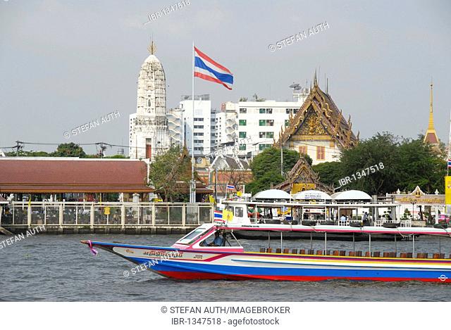 Boat on the Mae Nam Chao Phraya River, Thai national flag, in the back a Buddhist temple, Bangkok, Thailand, Southeast Asia, Asia