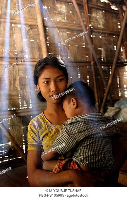 An ethnic girl holding a child on her lap at Tindu Bandarban, Bangladesh December 2009