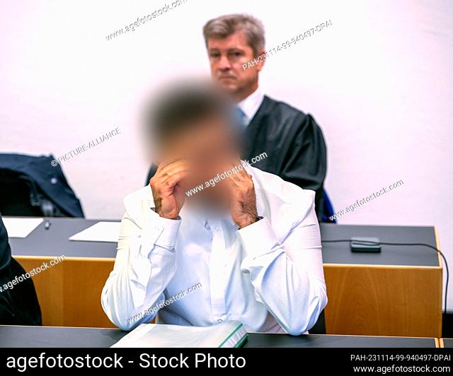 14 November 2023, Bavaria, Augsburg: A defendant sits in the dock in front of his defense attorney Werner Ruisinger in the district court