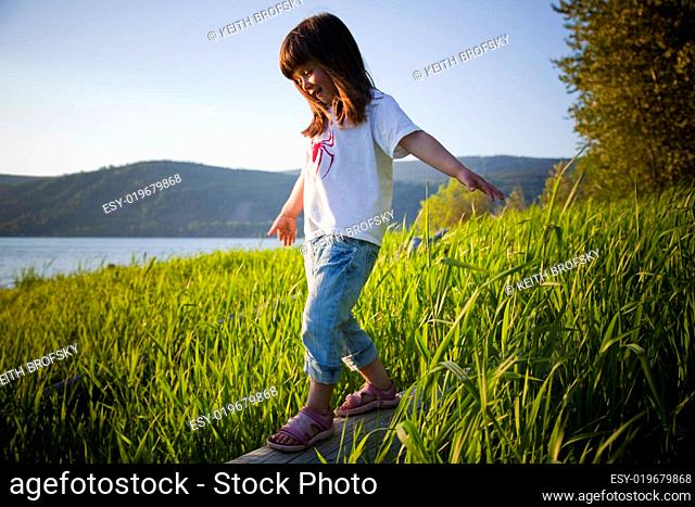 Girl Balancing on Log Near the Water