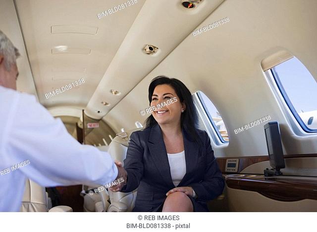 Business people shaking hands on private jet