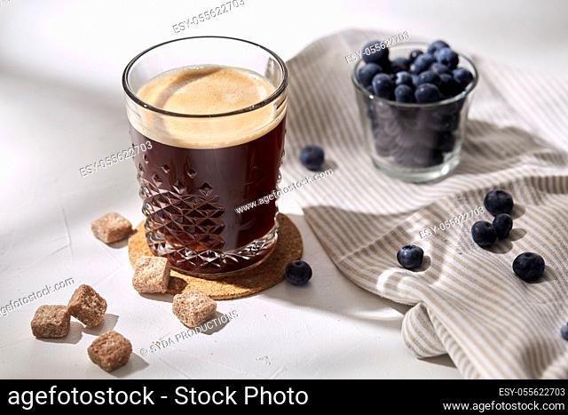 glass of coffee, brown sugar and blueberries