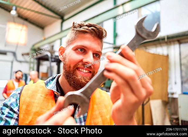 Handwerker Lehrling mit einem Schaubenschlüssel in der Werkstatt der Schlosserei