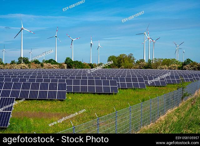 Sonnenenergie-Paneele mit Windturbinen im Rücken in Deutschland gesehen