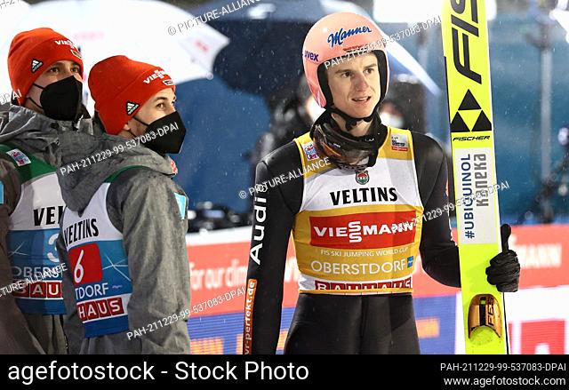 29 December 2021, Bavaria, Oberstdorf: Nordic skiing/ski jumping: World Cup, Four Hills Tournament. Karl Geiger (r) from Germany reacts after his jump in the...