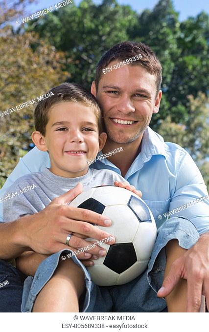 Cheerful dad and son with football