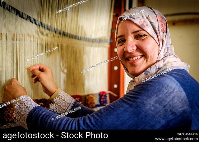A young Berber woman weaving a carpet in Tazenakht, southern Morocco, North Africa