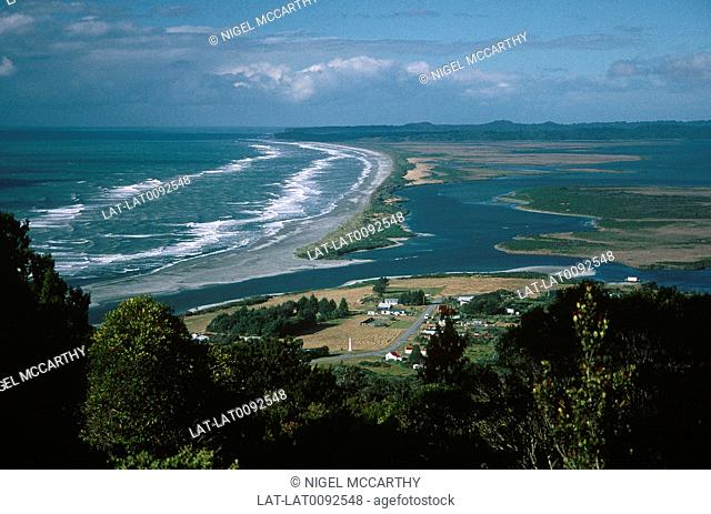 View over Okarito sea lagoon. View along coast. White waves of ocean. Volcanic landscape feature