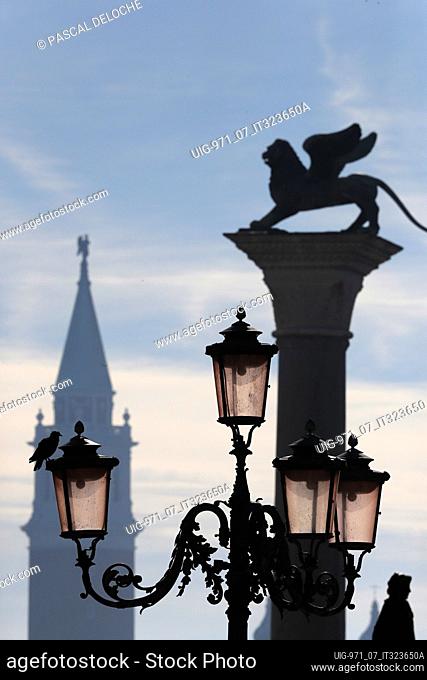 Lion of Saint Mark and church. Lantern, winged lion and belltower of the Basilica di Santa Maria della Salute. Venice. Italy