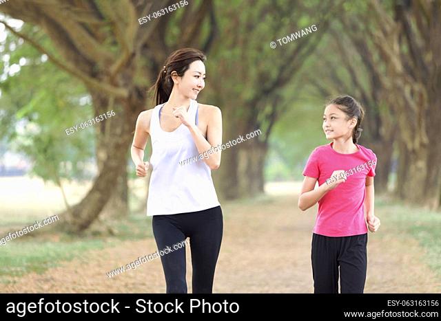 Happy Mother and daughter jogging in the park