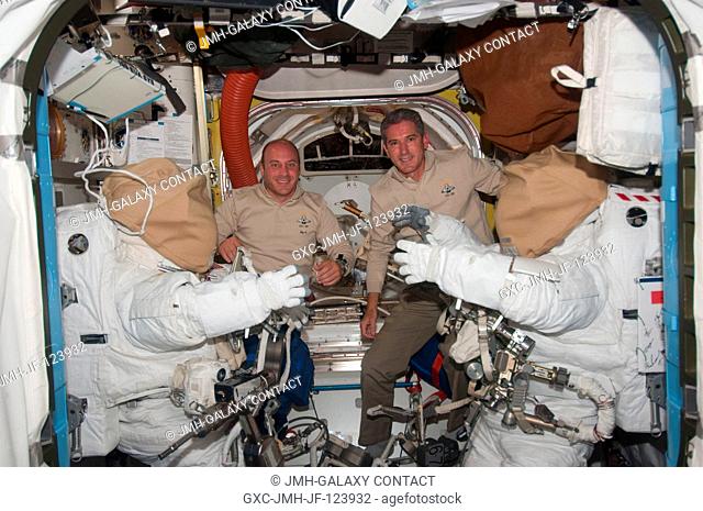 NASA astronauts Garrett Reisman (left) and Michael Good, both STS-132 mission specialists, pose for a photo between two Extravehicular Mobility Unit (EMU)...
