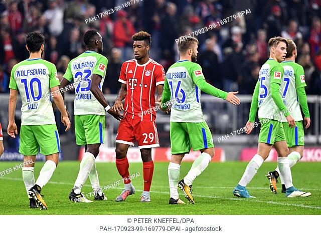 Munich's Kingsley Coman (M) stands between Wolfsburg's players Yunus Malli (L-R), Josuha Guilavogui, Jakub Blaszczykowski
