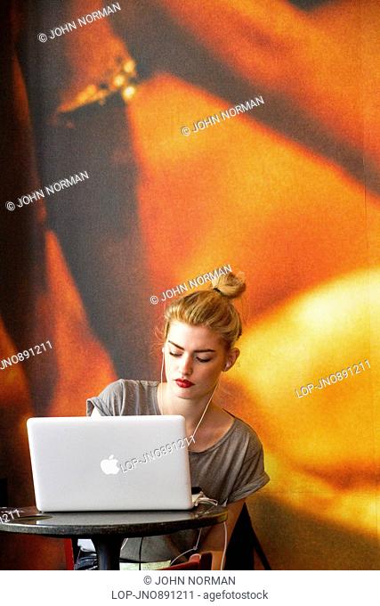 A young woman working at her lap-top in a Soho coffee-shop