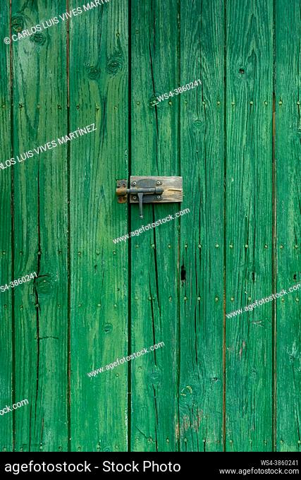 Old wooden door with aged metal door handle. Architectural textured background,