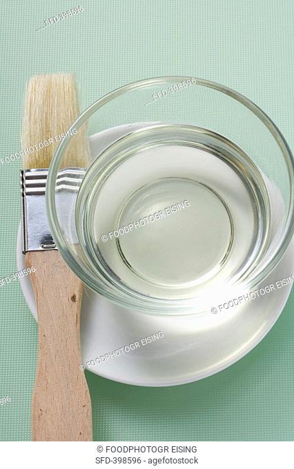 Rapeseed oil in a small dish with pastry brush